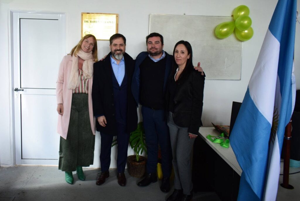 Autoridades y referentes posando junto a la placa del Aula de Capacitación y Formación Dr. Roberto Conti en la Casa Central de LESIS.